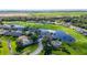 Sprawling aerial view of residences bordering a golf course and lake with lush greenery at 11247 Corey Pavin Ln, San Antonio, FL 33576