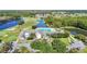 Aerial view of the community clubhouse, a pool, and a golf course surrounded by picturesque lakes at 11247 Corey Pavin Ln, San Antonio, FL 33576