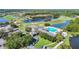 Aerial view of the community clubhouse, a pool, and a golf course surrounded by picturesque lakes at 11247 Corey Pavin Ln, San Antonio, FL 33576