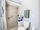 Bright bathroom featuring a walk-in shower with safety bar, gray walls, and organized towel storage at 11247 Corey Pavin Ln, San Antonio, FL 33576
