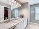 Bathroom featuring granite counters with double sinks, modern fixtures and a large decorative mirror at 11247 Corey Pavin Ln, San Antonio, FL 33576