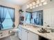 Bathroom featuring granite counters, white cabinets, decorative mirror, and modern fixtures at 11247 Corey Pavin Ln, San Antonio, FL 33576