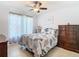Comfortable bedroom with leafy comforter, ceiling fan, and window with patterned curtains at 11247 Corey Pavin Ln, San Antonio, FL 33576