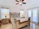 Bedroom featuring a decorative headboard, tiled flooring, and two windows with privacy blinds at 11247 Corey Pavin Ln, San Antonio, FL 33576