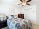 Inviting bedroom featuring a ceiling fan, bed with a decorative leafy comforter and bedside tables at 11247 Corey Pavin Ln, San Antonio, FL 33576