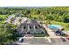Aerial shot of clubhouse with a parking lot, palm trees, and a community pool at 11247 Corey Pavin Ln, San Antonio, FL 33576