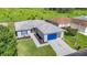 Charming single Gathering home featuring a well-maintained lawn, a vibrant blue garage door, and screened-in porch at 11247 Corey Pavin Ln, San Antonio, FL 33576