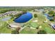 Scenic aerial view of the lush golf course with a beautiful lake and well-manicured greens at 11247 Corey Pavin Ln, San Antonio, FL 33576