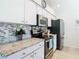 Kitchen with stainless steel appliances, granite countertops, and tile backsplash at 11247 Corey Pavin Ln, San Antonio, FL 33576