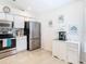 Bright kitchen featuring stainless steel refrigerator, white cabinets, and tile flooring at 11247 Corey Pavin Ln, San Antonio, FL 33576