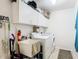 A functional laundry room featuring a utility sink, washer, dryer, and overhead storage cabinets at 11247 Corey Pavin Ln, San Antonio, FL 33576