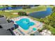 Aerial view of the community's unique shaped pool, surrounded by lounge chairs and palm trees at 11247 Corey Pavin Ln, San Antonio, FL 33576