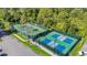 Aerial view of community tennis and pickleball courts, surrounded by mature trees at 11247 Corey Pavin Ln, San Antonio, FL 33576