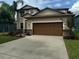 Two story house with brown garage door and landscaping at 12433 Duckett Ct, Spring Hill, FL 34610