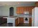 Kitchen with wood cabinets, white appliances, and granite countertops at 10312 Cleghorn Dr, San Antonio, FL 33576