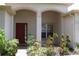 Inviting front entrance with arched entryway and lush landscaping at 10312 Cleghorn Dr, San Antonio, FL 33576