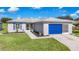 Single-Gathering home with gray exterior, blue garage door, and landscaped yard at 11247 Corey Pavin Ln, San Antonio, FL 33576