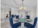 Dining area featuring a round glass table with blue upholstered chairs and a mirrored accent wall at 1651 Sand Key Estates Ct # 74, Clearwater Beach, FL 33767