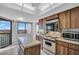 Kitchen showcasing appliances, wood cabinets, a ceiling fan, and a large window with a view at 1651 Sand Key Estates Ct # 74, Clearwater Beach, FL 33767