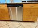 Stainless steel dishwasher next to wood cabinets and tile floors at 5830 Midnight Pass Rd # 705, Sarasota, FL 34242