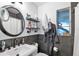 Contemporary bathroom with dark-grey tile, round mirror and floating shelves at 4984 Oxford N Ave, St Petersburg, FL 33710