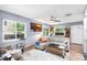 Light-filled living room with sectional sofa, wood flooring, and ceiling fan at 4984 Oxford N Ave, St Petersburg, FL 33710