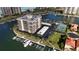 Aerial view of waterfront condo building with tennis court and marina at 1651 Sand Key Estates Ct # 74, Clearwater Beach, FL 33767