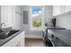 Bright laundry room with sink and ample storage at 158 Brightwater Dr # 1, Clearwater Beach, FL 33767