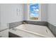 Relaxing bathroom with a soaking tub and a view of the water at 158 Brightwater Dr # 1, Clearwater Beach, FL 33767