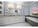 Modern bathroom with double vanity, large mirror, and bathtub at 158 Brightwater Dr # 1, Clearwater Beach, FL 33767