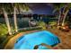 Luxury pool and spa at night with waterway and boat views at 10109 Tarpon Dr, Treasure Island, FL 33706