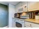 Bright kitchen features white cabinets, black stovetop, microwave, and built-in oven at 7200 Ulmerton Rd # F2, Largo, FL 33771