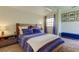 Spacious bedroom with a wooden bed frame, blue bedding, and a window with blinds at 7200 Ulmerton Rd # F2, Largo, FL 33771