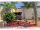 Tan Florida condo with palm trees, brick pathway, and red mulch landscaping at 7200 Ulmerton Rd # F2, Largo, FL 33771