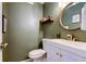 Modern bathroom with white vanity, green walls, and gold fixtures at 7200 Ulmerton Rd # F2, Largo, FL 33771