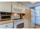 White kitchen with oven, stove, microwave and cabinets at 7200 Ulmerton Rd # F2, Largo, FL 33771