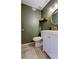 Updated half bathroom with white vanity and green walls, includes stylish rug at 7200 Ulmerton Rd # F2, Largo, FL 33771