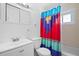 Bathroom with white vanity, toilet, and colorful shower curtain at 5575 6Th N Ave, St Petersburg, FL 33710