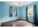 Bedroom with light blue walls, wood floors, and patterned curtains at 5575 6Th N Ave, St Petersburg, FL 33710