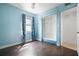 Bedroom with light blue walls, wood floors, and built-in shelving at 5575 6Th N Ave, St Petersburg, FL 33710