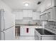 White kitchen with appliances and granite countertops at 5575 6Th N Ave, St Petersburg, FL 33710