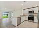 Modern kitchen with white cabinets, stainless steel appliances, and island at 5552 Logan Cave Ave, Wimauma, FL 33598