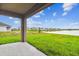 Spacious covered patio with a view of a lake and houses at 5552 Logan Cave Ave, Wimauma, FL 33598
