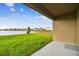 Covered patio overlooking a lake and grassy yard with houses in the background at 5552 Logan Cave Ave, Wimauma, FL 33598