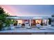 Beautiful modern outdoor living space with lounge seating, fire pit, and open access to the home's interior at 440 64Th Ave, St Pete Beach, FL 33706