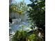 Lush outdoor retreat featuring a modern tub near a tranquil pond with tropical plants all around at 440 64Th Ave, St Pete Beach, FL 33706