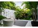 Serene backyard oasis boasting a modern tub and chair surrounded by tropical plants against a textured wall at 440 64Th Ave, St Pete Beach, FL 33706