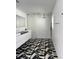 Modern bathroom with geometric tile floor, floating vanity, black fixtures, and a walk-in shower at 440 64Th Ave, St Pete Beach, FL 33706