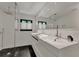 Modern bathroom featuring dual sinks, sleek black and white tile, and a glass-enclosed shower at 440 64Th Ave, St Pete Beach, FL 33706