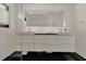 Modern bathroom with double sink vanity, large mirror, and black tile flooring at 440 64Th Ave, St Pete Beach, FL 33706